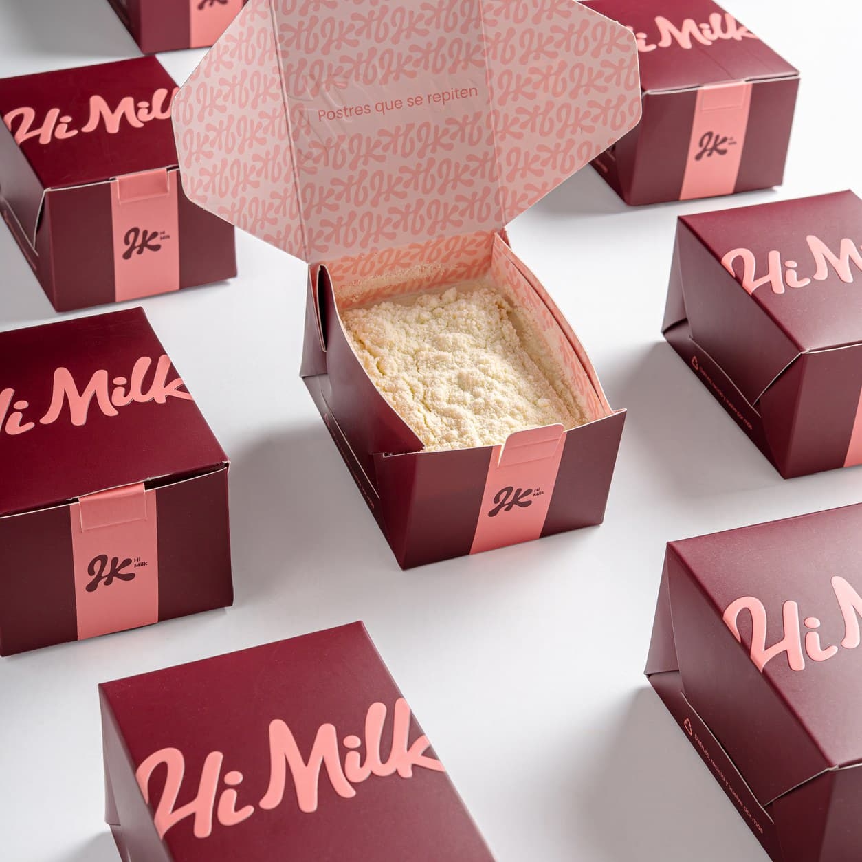 Caja Hi Milk abierta con el postre Explosión de Leche Klim y una cucharada cremosa